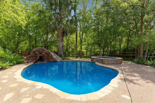 2042 Darby Ln, Fresno, TX 77545 - view of pool with a fenced backyard, a water slide, a pool with connected hot tub, view of wooded area, and a patio area