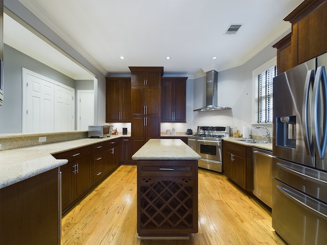 6319 Riverview Way, Houston, TX 77057 - kitchen with appliances with stainless steel finishes, wall chimney range hood, a sink, crown molding, and a center island