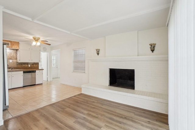 2112 Leyte Dr, Tool, TX 75143 - unfurnished living room featuring a ceiling fan, light tile patterned floors, a fireplace, and a sink