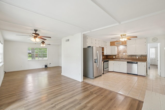 2112 Leyte Dr, Tool, TX 75143 - kitchen featuring stainless steel appliances, ceiling fan, light wood finished floors, white cabinetry, and open floor plan