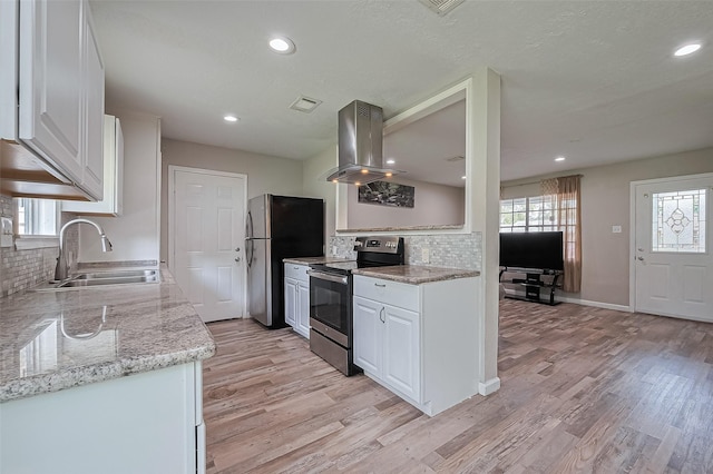 6134 Guadalupe St, Houston, TX 77016 - kitchen featuring stainless steel appliances, island exhaust hood, a sink, backsplash, and white cabinets