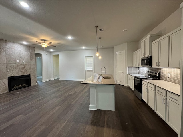 3522 Stonehenge, Montgomery, TX 77356 - kitchen featuring stainless steel appliances, baseboards, open floor plan, dark wood finished floors, and a ceiling fan