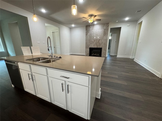 3522 Stonehenge, Montgomery, TX 77356 - kitchen with a sink, a ceiling fan, a center island with sink, baseboards, and a fireplace