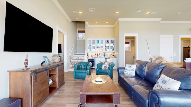 2414 Sand Drift Ln, Crystal Beach, TX 77650 - living room with wine cooler, light wood-type flooring, ornamental molding, recessed lighting, and a dry bar