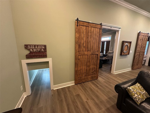 2414 Sand Drift Ln, Crystal Beach, TX 77650 - living area with baseboards, a barn door, dark wood-style flooring, and ornamental molding