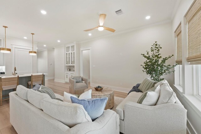 4046 Miramar Ct, Galveston, TX 77554 - living room with light wood finished floors, recessed lighting, ceiling fan, baseboards, and crown molding