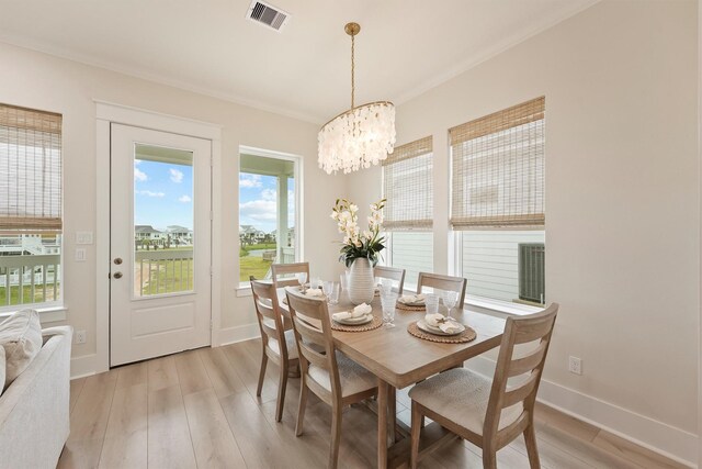4046 Miramar Ct, Galveston, TX 77554 - dining room with a chandelier, light wood finished floors, and baseboards