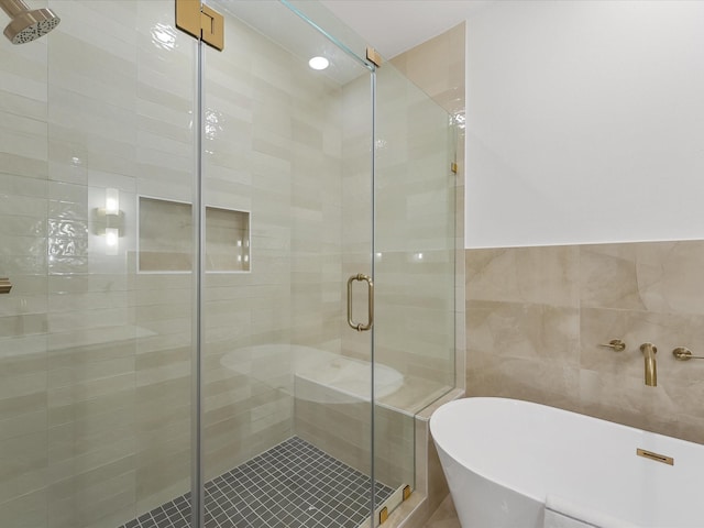 5014 Golden Forest Dr, Houston, TX 77091 - bathroom featuring a freestanding tub, a shower stall, and tile walls
