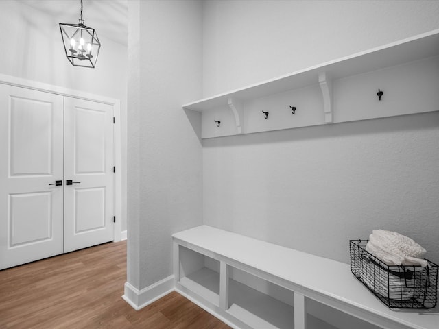 17511 Autumn Leaves Dr, Conroe, TX 77302 - mudroom with a chandelier, wood finished floors, baseboards, and a textured wall