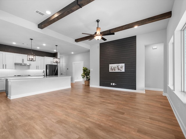 17511 Autumn Leaves Dr, Conroe, TX 77302 - unfurnished living room with beamed ceiling, ceiling fan, recessed lighting, light wood-style floors, and baseboards