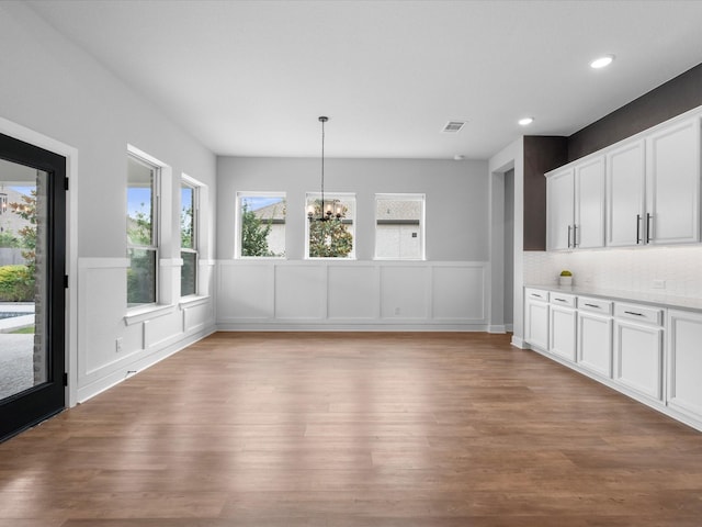 17511 Autumn Leaves Dr, Conroe, TX 77302 - unfurnished dining area featuring a chandelier, a wainscoted wall, light wood finished floors, a decorative wall, and recessed lighting