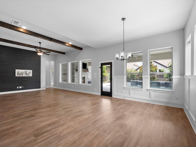 17511 Autumn Leaves Dr, Conroe, TX 77302 - unfurnished living room with a chandelier, a ceiling fan, wood finished floors, beam ceiling, and wainscoting