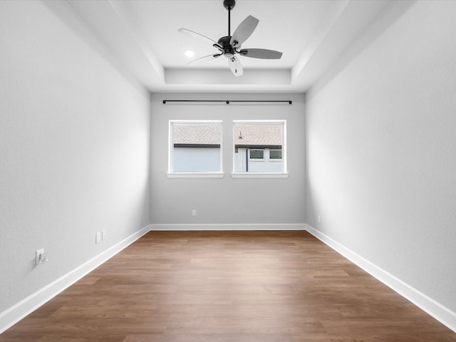 17511 Autumn Leaves Dr, Conroe, TX 77302 - unfurnished room with ceiling fan, a raised ceiling, wood finished floors, and baseboards
