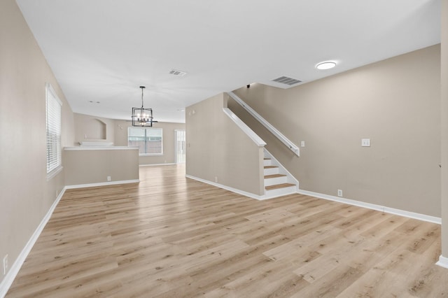 19222 Wading River Dr, Tomball, TX 77375 - unfurnished living room featuring light wood-style flooring, a chandelier, stairway, and baseboards