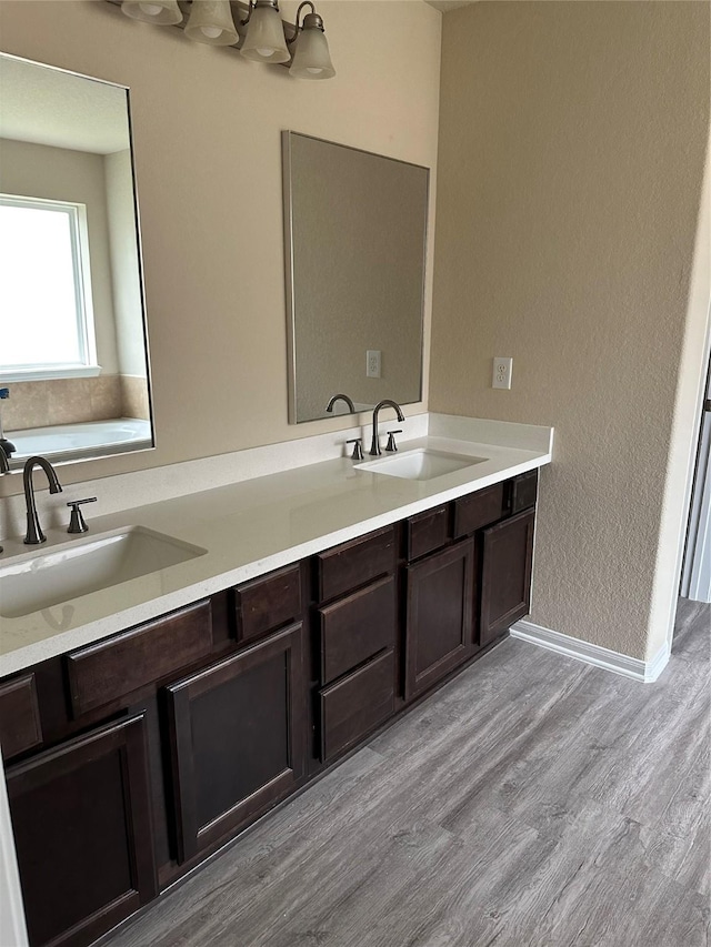 3423 Single Ridge Way, Katy, TX 77493 - bathroom featuring double vanity, wood finished floors, and baseboards