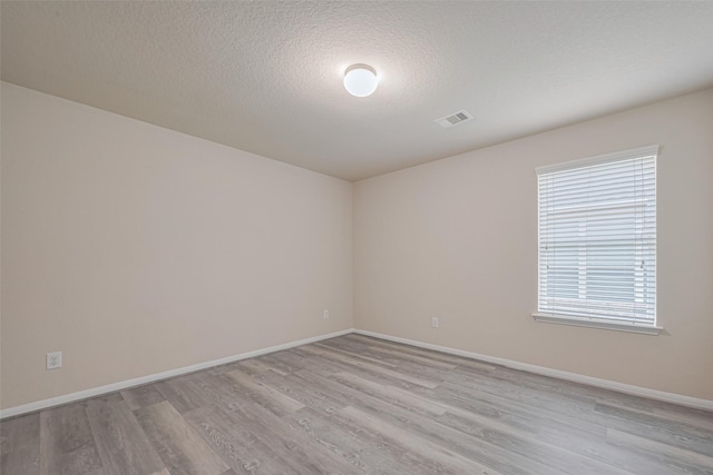 3423 Single Ridge Way, Katy, TX 77493 - empty room with light wood-style floors, baseboards, and a textured ceiling