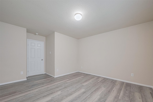 3423 Single Ridge Way, Katy, TX 77493 - empty room featuring light wood-style flooring, baseboards, and a textured ceiling