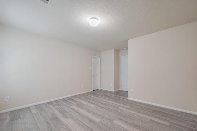 3423 Single Ridge Way, Katy, TX 77493 - spare room featuring light wood finished floors, baseboards, and a textured ceiling
