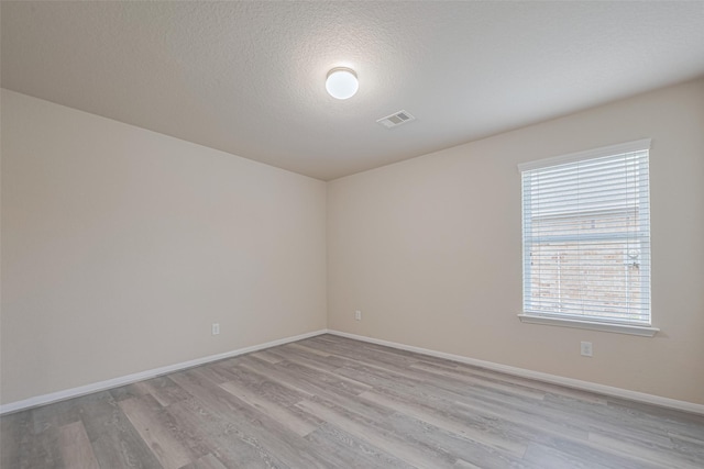 3423 Single Ridge Way, Katy, TX 77493 - empty room with light wood-type flooring, baseboards, and a textured ceiling