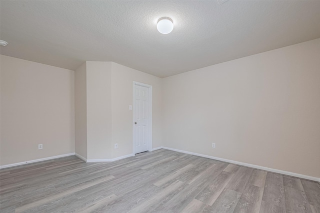 3423 Single Ridge Way, Katy, TX 77493 - unfurnished room with light wood-style flooring, baseboards, a textured ceiling, and a smoke detector