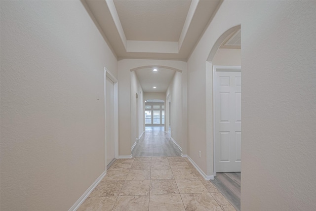 3423 Single Ridge Way, Katy, TX 77493 - hallway featuring arched walkways, a textured wall, and baseboards