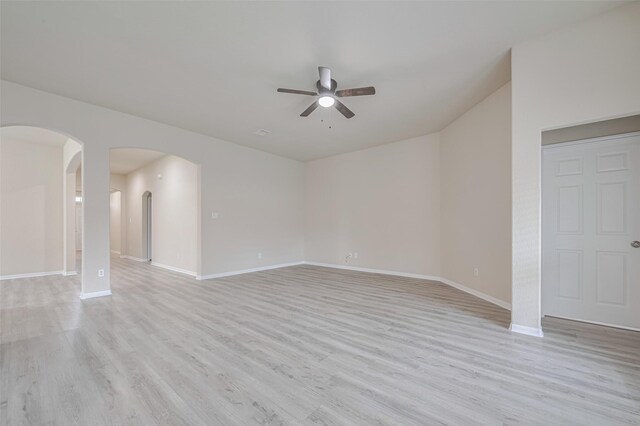 3423 Single Ridge Way, Katy, TX 77493 - unfurnished living room featuring a ceiling fan, light wood-style flooring, arched walkways, and baseboards
