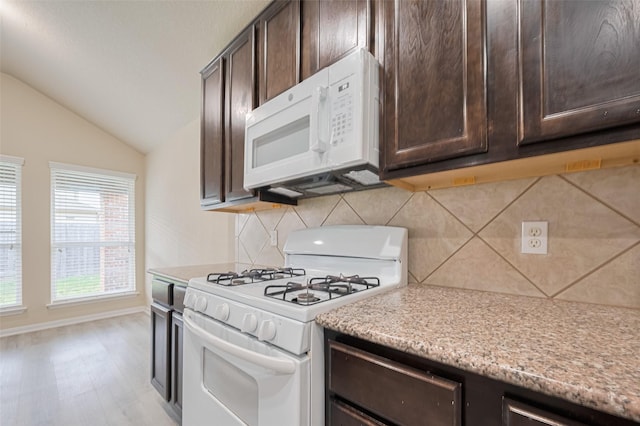3423 Single Ridge Way, Katy, TX 77493 - kitchen with white appliances, dark brown cabinets, vaulted ceiling, and decorative backsplash