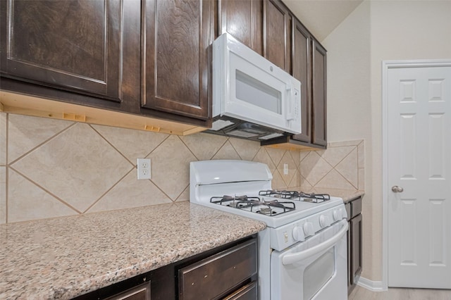 3423 Single Ridge Way, Katy, TX 77493 - kitchen featuring white appliances, dark brown cabinets, decorative backsplash, and light stone countertops