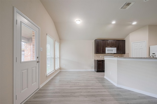 3423 Single Ridge Way, Katy, TX 77493 - kitchen with white appliances, vaulted ceiling, dark brown cabinetry, light wood-type flooring, and decorative backsplash