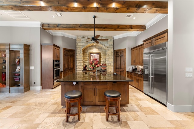 2722 N Southern Oaks Dr, Houston, TX 77068 - kitchen featuring appliances with stainless steel finishes, stone tile floors, ceiling fan, beamed ceiling, and a breakfast bar