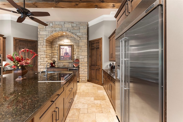 2722 N Southern Oaks Dr, Houston, TX 77068 - kitchen with stainless steel appliances, stone tile floors, ceiling fan, ornamental molding, and dark stone counters
