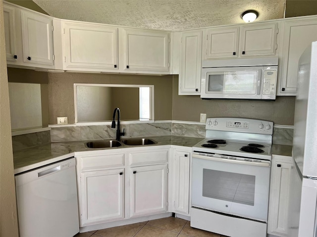 2503 Ironclad Dr, League City, TX 77573 - kitchen with white appliances, a sink, light tile patterned floors, and white cabinets