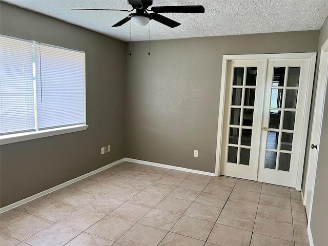 2503 Ironclad Dr, League City, TX 77573 - empty room with french doors, ceiling fan, light tile patterned floors, a textured ceiling, and baseboards
