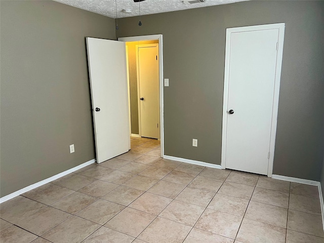 2503 Ironclad Dr, League City, TX 77573 - unfurnished bedroom featuring light tile patterned floors, baseboards, and a textured ceiling