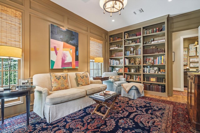 3428 Wickersham Ln, Houston, TX 77027 - living area with built in shelves, a chandelier, wood finished floors, recessed lighting, and a decorative wall