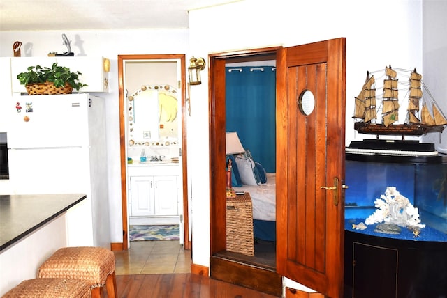 26656 Fm 457, Sargent, TX 77414 - kitchen with freestanding refrigerator, a sink, and wood finished floors