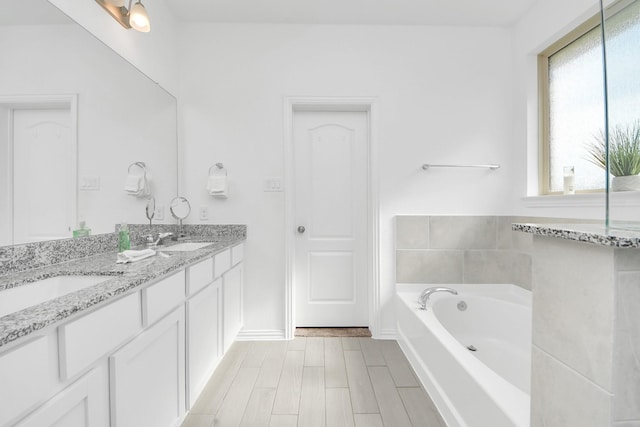 8034 Royal Palm Dr, Fulshear, TX 77441 - bathroom featuring plenty of natural light, double vanity, a bath, and baseboards