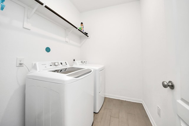 8034 Royal Palm Dr, Fulshear, TX 77441 - laundry area with separate washer and dryer, light wood finished floors, and baseboards