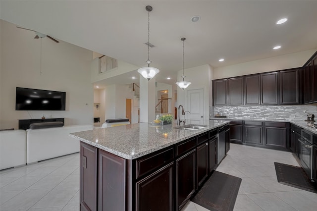 27003 Lindenwood Creek Ln, Katy, TX 77494 - kitchen featuring a sink, light tile patterned flooring, tasteful backsplash, light stone countertops, and open floor plan