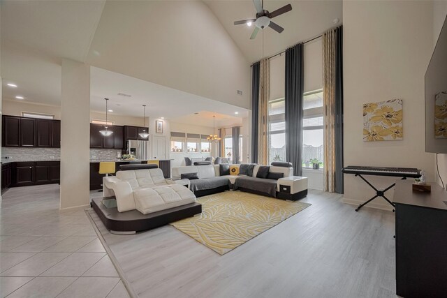 27003 Lindenwood Creek Ln, Katy, TX 77494 - living room with a ceiling fan, a chandelier, a towering ceiling, light wood-style floors, and recessed lighting