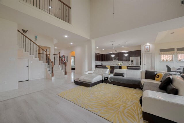 27003 Lindenwood Creek Ln, Katy, TX 77494 - living room featuring a towering ceiling, plenty of natural light, recessed lighting, stairs, and light wood-style floors