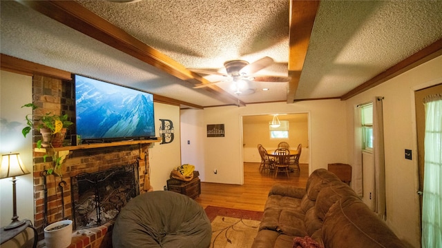 205 Mesa Dr, Gatesville, TX 76528 - living room featuring a textured ceiling, wood finished floors, a ceiling fan, a fireplace, and beam ceiling