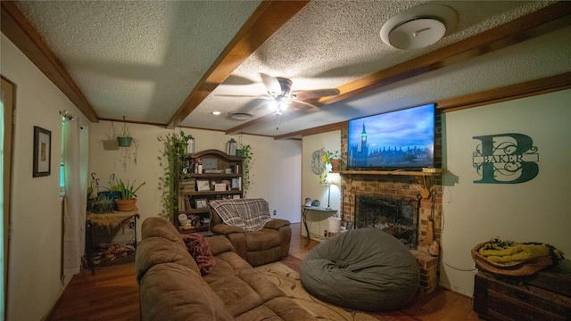 205 Mesa Dr, Gatesville, TX 76528 - living area featuring a textured ceiling, wood finished floors, ceiling fan, a fireplace, and beamed ceiling