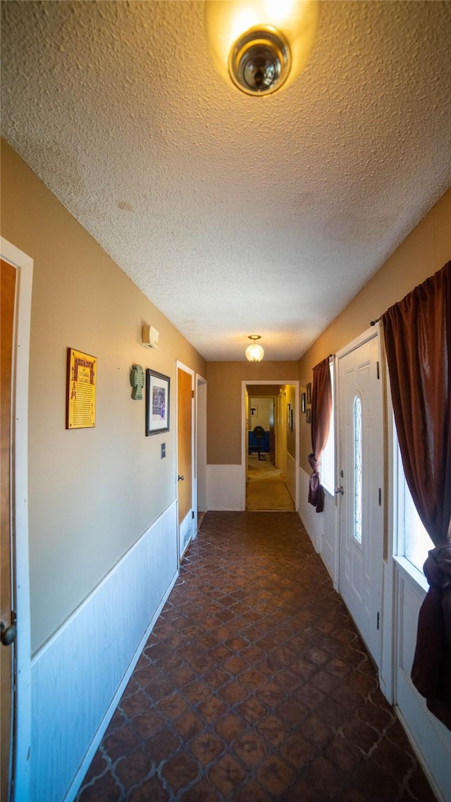 205 Mesa Dr, Gatesville, TX 76528 - hall with a textured ceiling, wainscoting, and stone finish floors