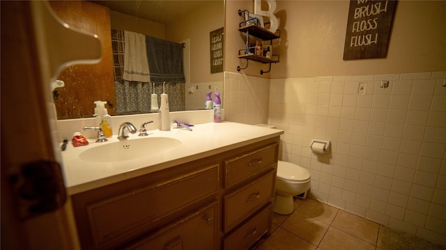 205 Mesa Dr, Gatesville, TX 76528 - bathroom with tile walls, toilet, vanity, tile patterned floors, and a wainscoted wall