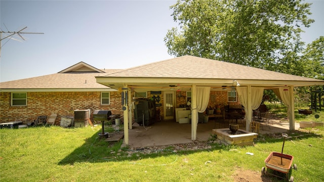 205 Mesa Dr, Gatesville, TX 76528 - back of property featuring ceiling fan, a patio, a lawn, roof with shingles, and brick siding
