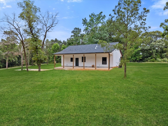 71 Prescott Dr, New Waverly, TX 77358 - back of house with a yard, view of wooded area, and board and batten siding