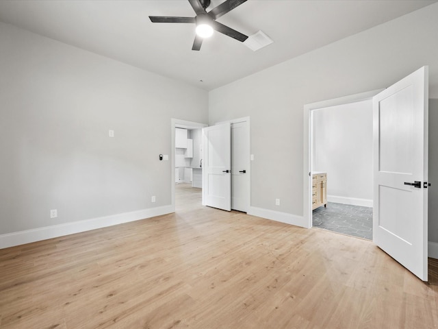 71 Prescott Dr, New Waverly, TX 77358 - unfurnished bedroom featuring light wood-style floors, baseboards, ensuite bath, and ceiling fan