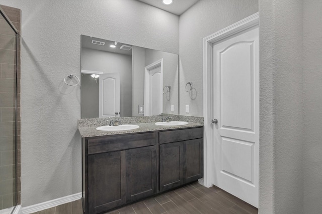 24742 Russet Bluff Trl, Houston, TX 77336 - full bathroom with a textured wall, wood finish floors, double vanity, and tiled shower