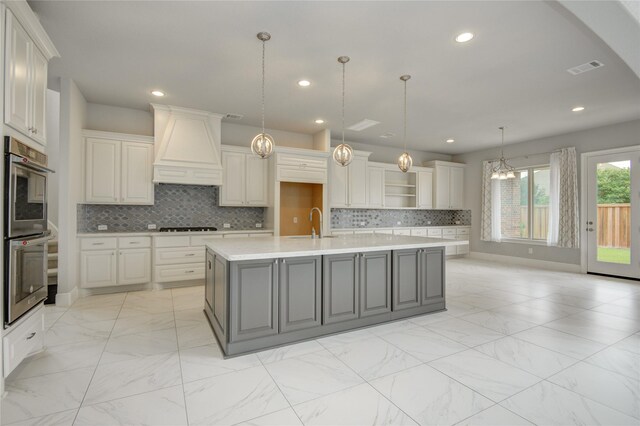 26510 Crimson Bluff Ln, Katy, TX 77494 - kitchen with premium range hood, stainless steel double oven, light marble finish flooring, light countertops, and a sink